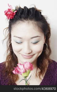 Close-up of a young woman smelling a flower