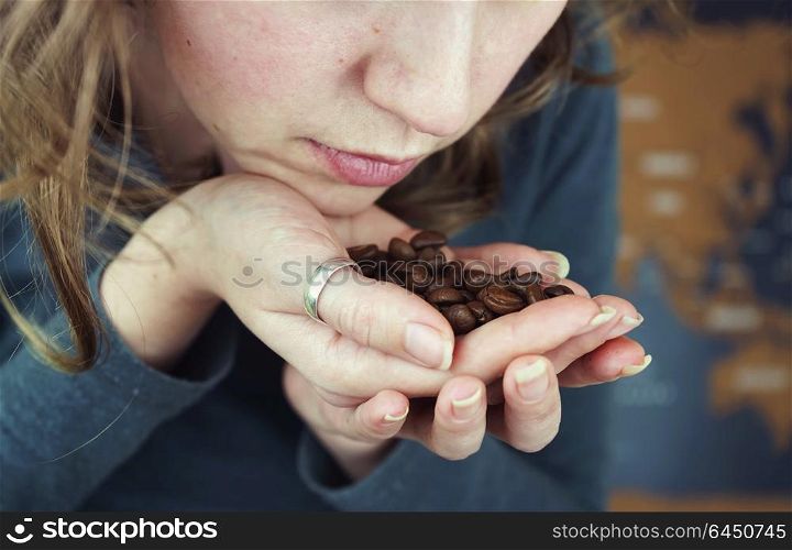 Close up of a young woman smelling coffee beans