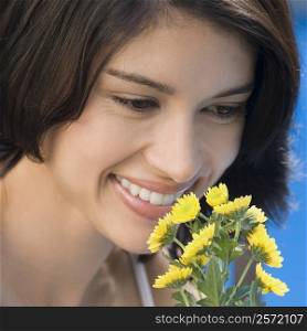 Close-up of a young woman smelling flowers and smiling