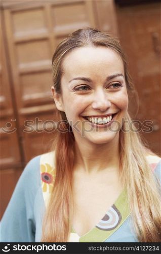 Close-up of a young woman smiling and looking away