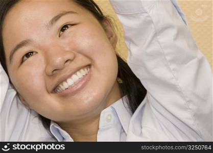 Close-up of a young woman smiling and stretching her arms