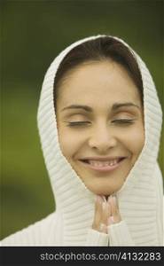 Close-up of a young woman smiling in a prayer position
