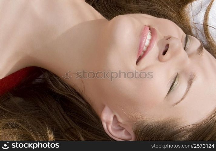 Close-up of a young woman smiling with her eyes closed