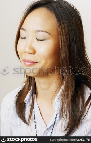 Close-up of a young woman smiling with her eyes closed