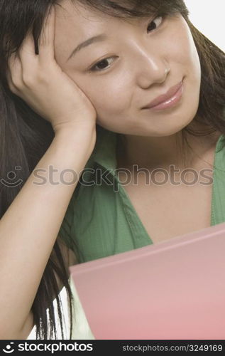 Close-up of a young woman smirking and looking at a file