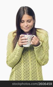 Close-up of a young woman standing and holding a cup of coffee