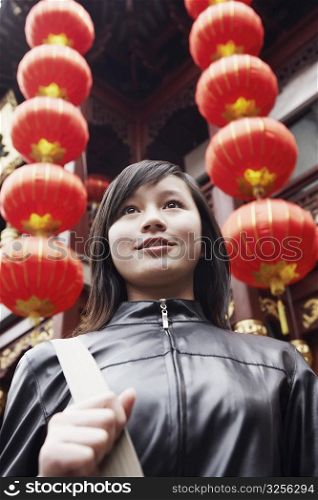 Close-up of a young woman standing in front of a Chinese lantern