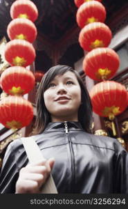 Close-up of a young woman standing in front of a Chinese lantern