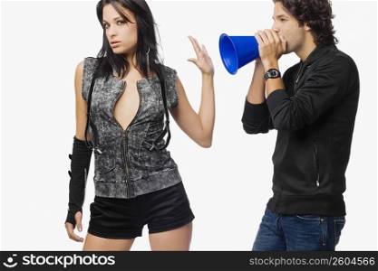 Close-up of a young woman stopping a young man to blow a megaphone