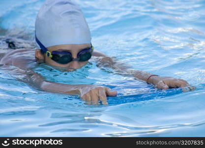 Close-up of a young woman swimming in a swimming pool