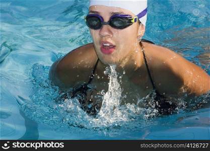 Close-up of a young woman swimming in a swimming pool
