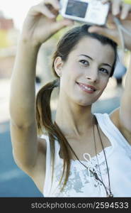 Close-up of a young woman taking a photograph of herself