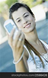 Close-up of a young woman taking a photograph of herself