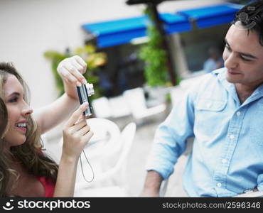 Close-up of a young woman taking a picture of a young man