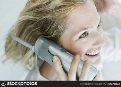 Close-up of a young woman talking on a cordless phone