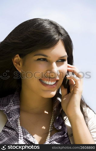 Close-up of a young woman talking on a mobile phone and smiling