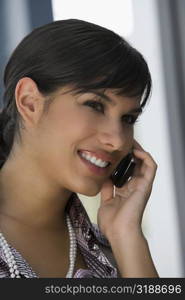 Close-up of a young woman talking on a mobile phone and smiling