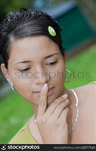 Close-up of a young woman thinking with her finger on her lips