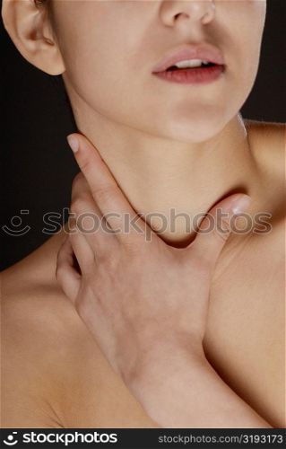 Close-up of a young woman touching her neck