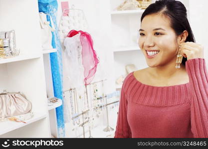 Close-up of a young woman trying on an earring in a store