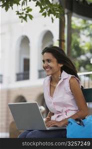 Close-up of a young woman using a laptop and smiling, Old San Juan, San Juan, Puerto Rico