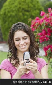 Close-up of a young woman using a mobile phone and smiling