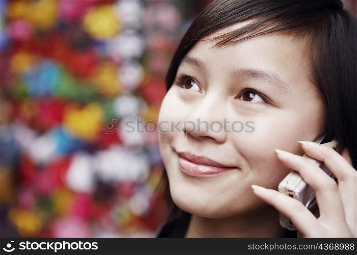 Close-up of a young woman using a mobile phone looking away