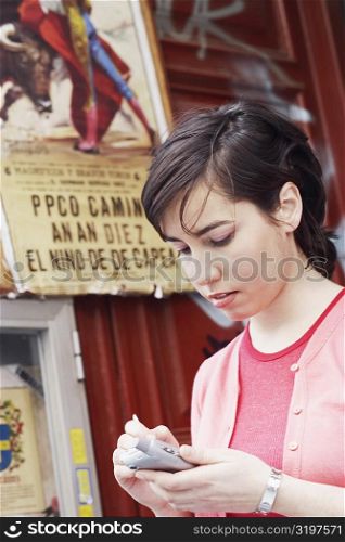 Close-up of a young woman using a personal data assistant
