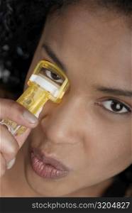 Close-up of a young woman using an eyelash curler