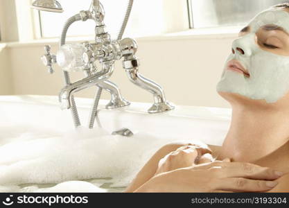 Close-up of a young woman wearing a facial mask in a bathtub