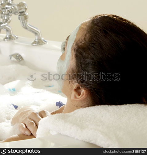 Close-up of a young woman wearing a facial mask in a bathtub