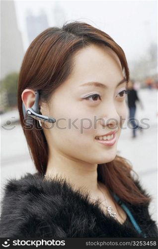 Close-up of a young woman wearing a hands free device