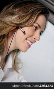 Close-up of a young woman wearing a hands free device and listening to music