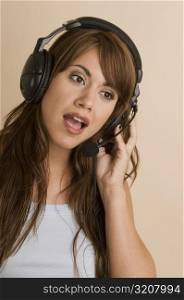 Close-up of a young woman wearing a headset and listening to music