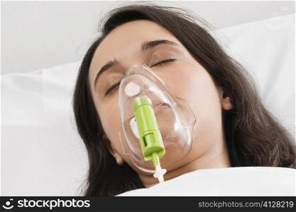 Close-up of a young woman wearing an oxygen mask