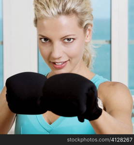 Close-up of a young woman wearing boxing gloves