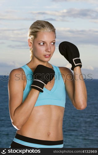 Close-up of a young woman wearing boxing gloves