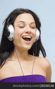 Close-up of a young woman wearing headphones and listening to music