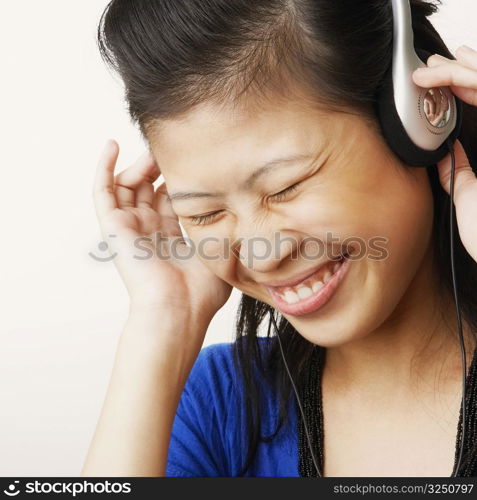 Close-up of a young woman wearing headphones and listening to music