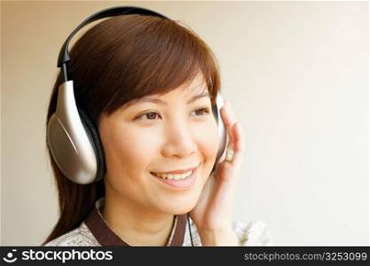 Close-up of a young woman wearing headphones and listening to music