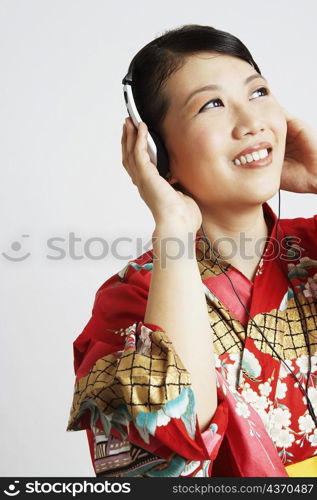 Close-up of a young woman wearing headphones and listening to music