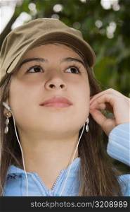 Close-up of a young woman wearing headphones and looking up
