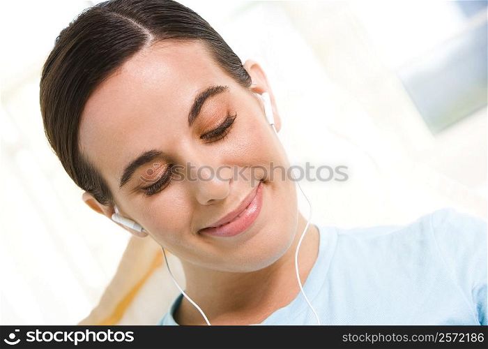 Close-up of a young woman wearing headphones listening to music