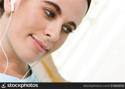 Close-up of a young woman wearing headphones listening to music