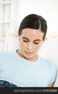 Close-up of a young woman wearing headphones listening to music