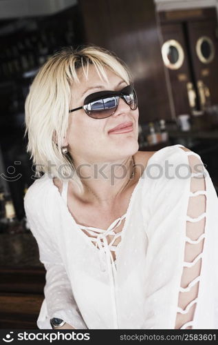 Close-up of a young woman wearing sunglasses and smirking