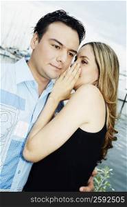 Close-up of a young woman whispering into a young man&acute;s ear