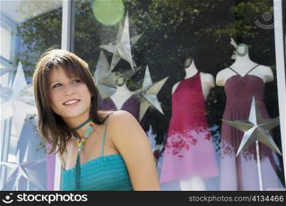 Close-up of a young woman window shopping and smiling