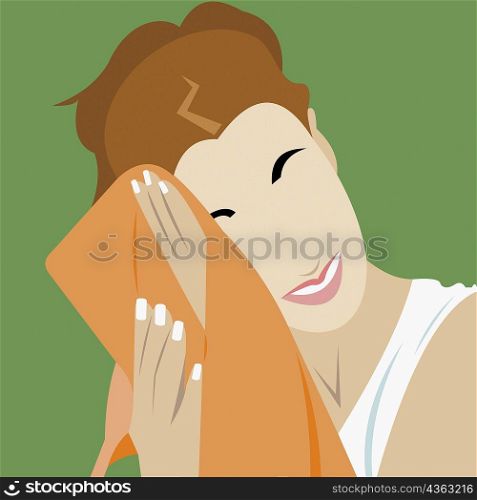 Close-up of a young woman wiping her face with a towel
