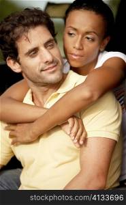 Close-up of a young woman wit her arms around a mid adult man